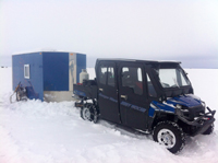 image of ATV trailering a wheel house ice fishing shelter