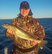 image of Matt Nistler holding Leech Lake Walleye in evening