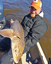 image of Colby Calhager with large sturgeon