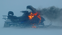 image of snowmobile burning on the ice