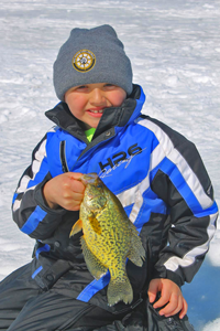 image of ice fishing kid holding crappie