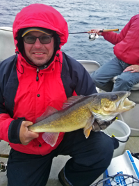 image of fisherman on four seasons launch trip holding walleye