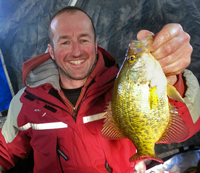 image of Mike Plackner holding Crappie on ice fishing trip