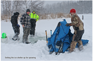 image of teens setting up ice fishing shelter