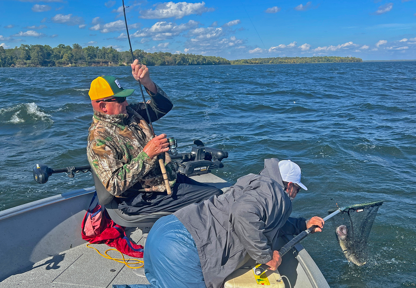 image of John Bugs Benton landing a nice walleye for Dana Cooke